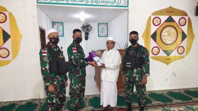 DOK. Danpos Muara Tami Satgas Pamtas Yonif 711/Rks Lettu Inf Richi Wahyu Prakoso berikan bantuan berupa Al-Qur’an dan perlengkapan alat sholat yang diterima langsung oleh Ustadz La Faiulu.