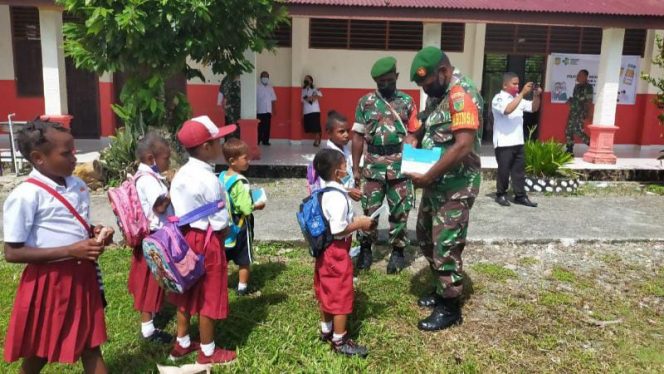 Babinsa Koramil 1710-03/Kuala Kencana membagikan masker gratis kepada siswa-siswi di SD Inpres, Kp. Limau Asri Barat, Distrik Iwaka, Kabupaten Mimika, Rabu (16/02/2022). FOTO : PENDAM XVII CENDERAWASIH