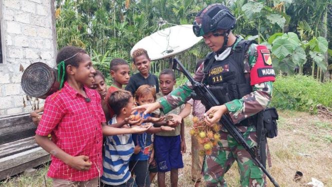 Foto anggota Satgas Pamtas RI-PNG Yonif 711/Rks dengan anak-anak di perbatasan Perbatasan Timur Papua.**