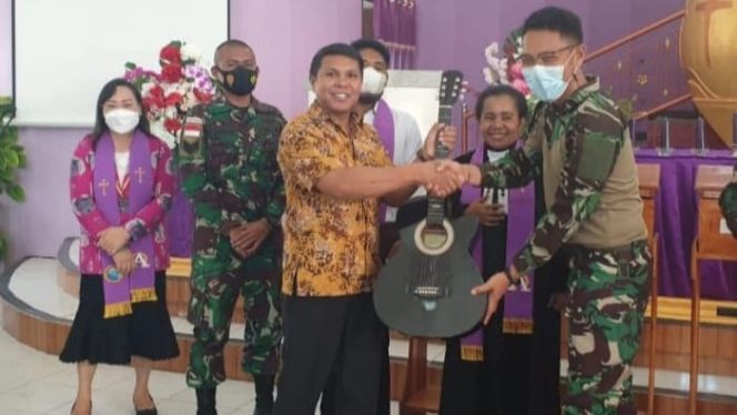 Personel Satgas Kodim Yalimo RK 751/VJS Letda Ckm Andreas menyerahkan bantuan alat musik berupa gitar kepada pihak Gereja GKI Imanuel Wamena, Kab. Jayawijaya. (SRIWIJAYADAILY/PENDAM CENDERAWASIH)