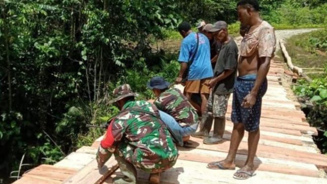 Babinsa Koramil 1709-03/Waropen Bawah (Warbah) di Distrik Inggerus Kab. Waropen memperbaiki jembatan yang rusak bersama-sama warga, Rabu (02/03/2022). FOTO : PENDAM XVII/CENDERAWASIH 