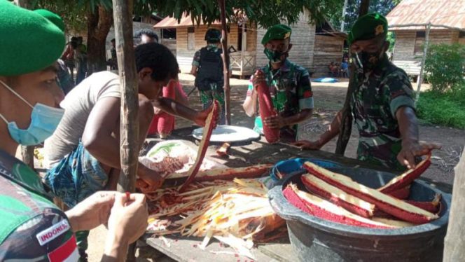 Foto anggota Pos Kondo Satgas 123 Rajawali Bantu Warga Perbatasan Papua Mengolah Buah Merah.**