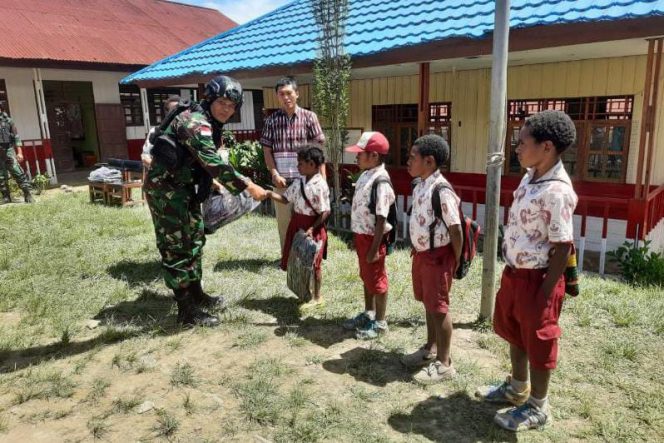 Satgas Pamtas Yonif Raider 142/KJ Bagikan Tas Sekolah Untuk Anak SD Negeri Karubaga./ FOTO : PEN SATGAS YONIF R 142