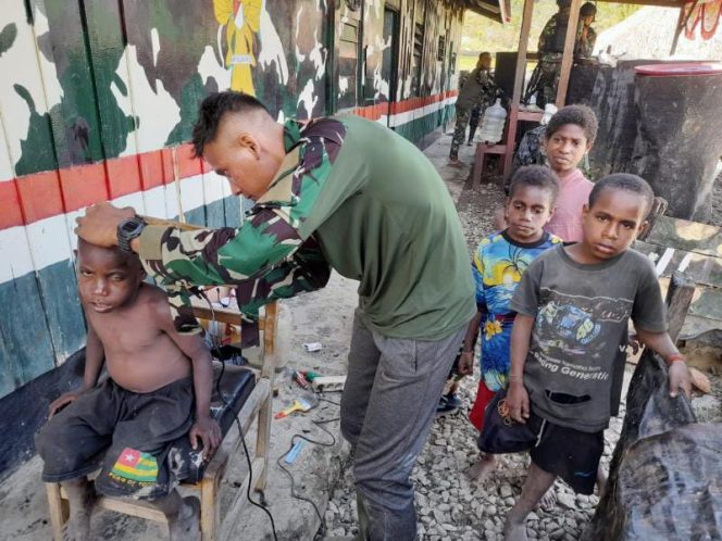 Anggota Satgas Yonif Raider 142/KJ di Pos Bolakme sedang memangkas rambut anak/ Foto : Pendam XVII/Cen