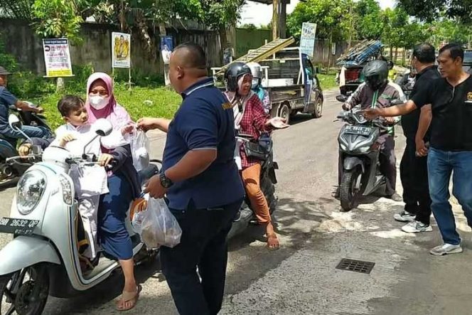 Keluarga Besar Himpunan Wong Sriwijaya Bersatu (HWSB) Provinsi Jambi tampak membagikan nasi bungkus di depan Sekretariiat HWSB Jalan Sunan Drajat Simpang Purnama Kelurahan Paal V Kecamatan Kota Baru, Kota Jambi siang tadi./ FOTO : Ist