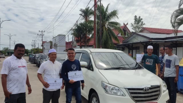 Anggota Seksi Transportasi Haul Syekh Abdul Qadir Al Jailani menempelkan stiker di Kendaraan antar jemput Jamaah. FOTO : Dok Dishub