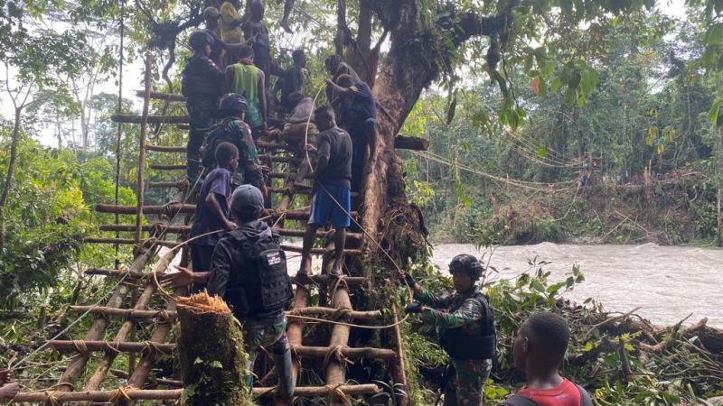 Satgas Yonif 143/TWEJ bersama warga membangun kembali jembatan darurat di atas Sungai Digoel/ FOTO : Pendam Sriwijaya